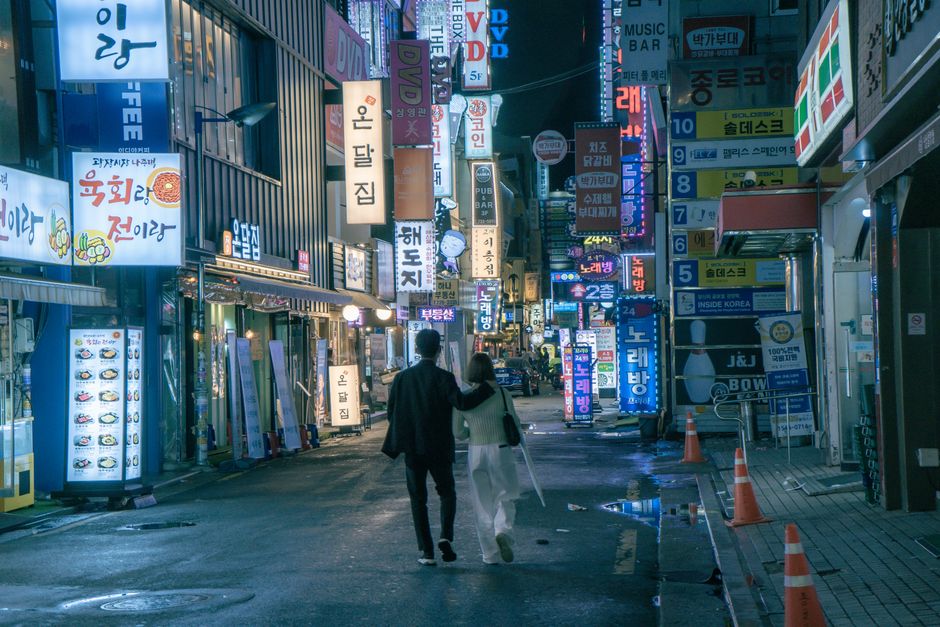 Two people walking a city street at night