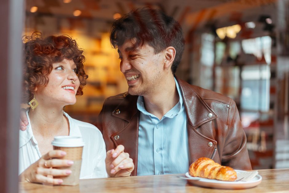 A couple laughing together at a cafe